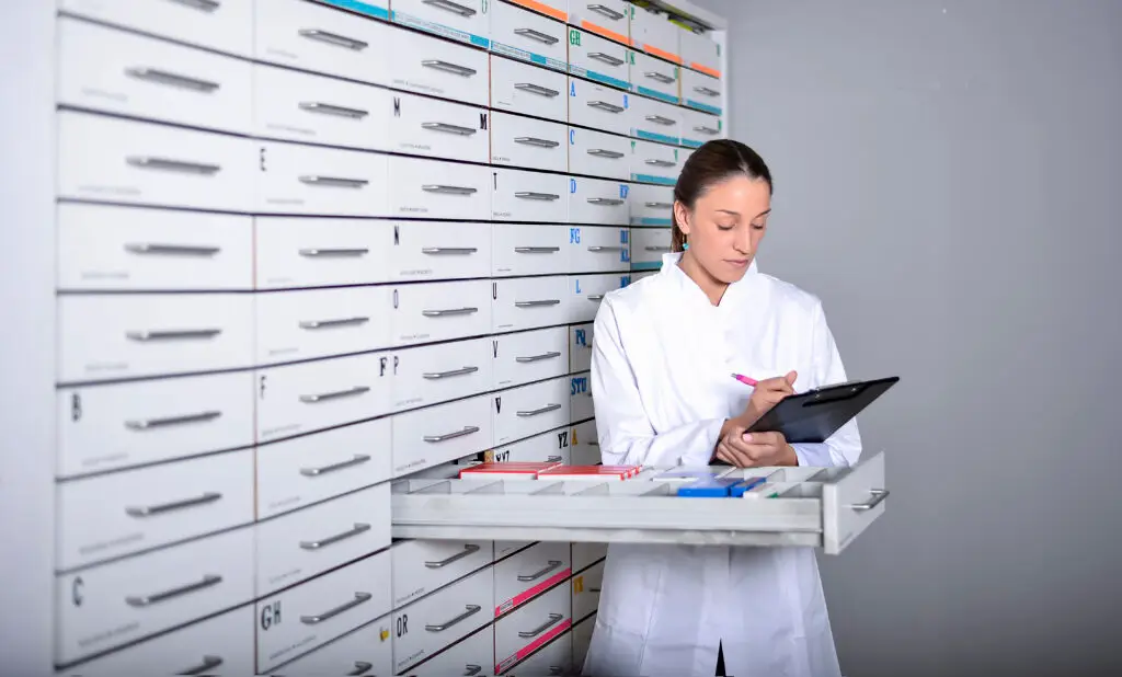 Miembro del equipo de farmacia organizando medicamentos