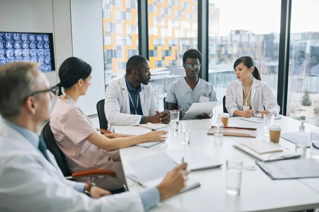 Médicos analizando imágenes médicas en una mesa de reuniones
