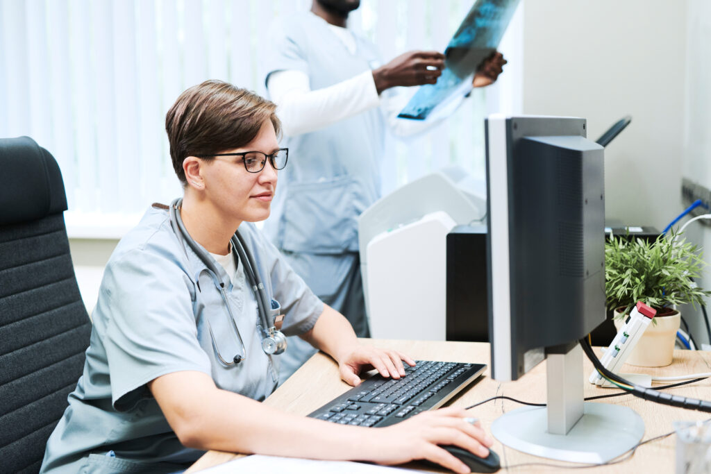 Médico trabajando con una computadora en una oficina